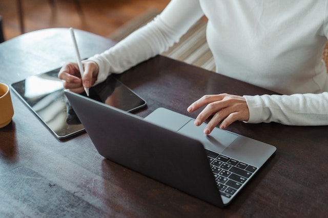 property-manager-sitting-at-desk-on-laptop-writing-notes