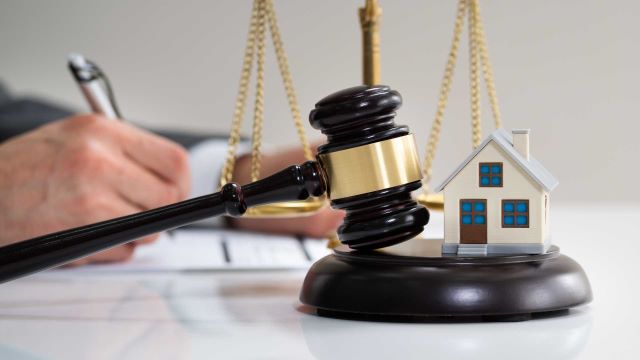 a gavel and house figurine